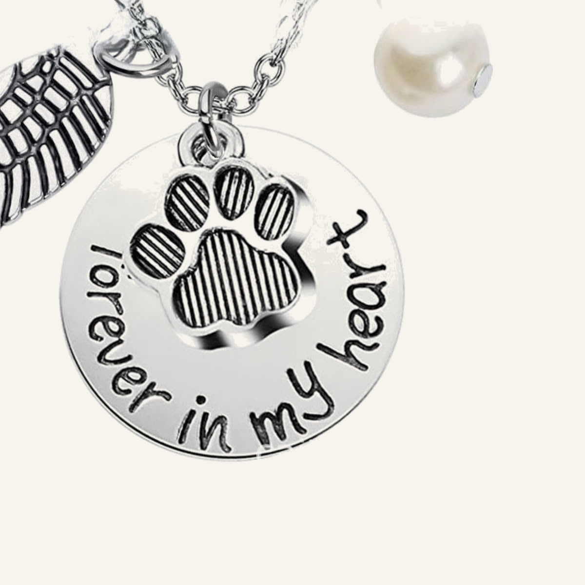Close-up of the round charm stamped forever in my heart with a paw print