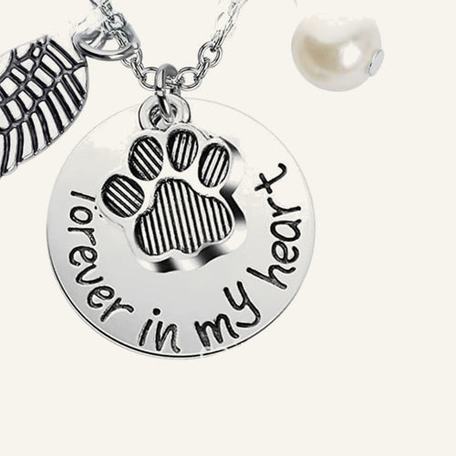 Close-up of the round charm stamped forever in my heart with a paw print